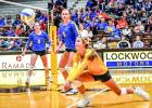 Abby Hennen digs out a shot with Lydia Sussner (5) and Morgan Kockelman (9) watching. 