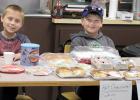 Taking advantage of the event to sell cookies and other goodies to raise money for their livestock project were Bekkem Gillund of Minneota (left) and Keaton King of Canby. 