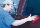  Cory Sandhurst worked on a vehicle, taking a stain off the side of a truck. He’s had to be versatile to get the job done. 