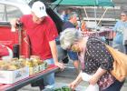 Judy Hagen, right, checks out the fresh vegetables being sold by Brian Pitzl of rural Minneota during the first week of the Farmers Market this past Thursday night at the west end of Veterans Park. 