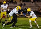 Minneota's Evan Jerzak (32), left, and Owen Myrvik (11) stop Lac qui Parle Valley quarterback Gavin Meyer after a short run Friday night in Madison. 