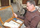 Randy Fox looks over Mascot newspaper clippings that included his father Lawrence boxing for Minneota in the mid-40s. 
