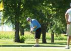 Brian Obe, center, putts while Gabe Piper, left, and Harlan Ulrich look on during competition in the First Flight. 
