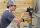 Charlie Pesch fills a quart jar with pure honey from a holding tank.