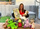 Kandy Noles Stevens of Marshall, holding a photo of her late son, Reed, poses with several of the stuffed animals they use to help families cope with the loss of a child. 