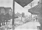 Following a two-day blizzard in 1916, snow was piled up in front of storefronts along Jefferson Street (looking south) after city workers cleared the street.