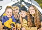Mariah Muhl, Jacob Haen, Reese Gillund and Merissa Traen sought shelter under an umbrella at the Minneota vs. Springfield football game on Friday in Minneota.