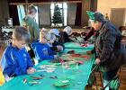 Sandy Josephson of the SPMH assists kids in making holiday crafts during “Christmas at the Opera Hall” on Saturday. 