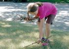 Staff photo by Scott Thoma. Hannah Heidecker picks up sticks and waters flowers as jobs in her business. She likes to keep busy and is looking for extra jobs for her new business venture.