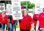 Nurse walk and hold picket signs.
