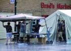 Raindrops fell on the Brad's Market tent as workers held down the awning during the rain storm. 
