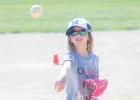 Calliope Thomsen plays catch with a teammate before their kindergarten T-ball game on Monday morning on the field behind the swimming pool. 