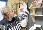 Staff Photo by Scott Thoma. Carla Thompson, the owner of Mary Louise, a vintage/antique store, stocks an item on a shelf during her Grand Opening ceremony that coincided with Small Business Saturday.