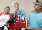Bill Sterzinger of Ivanhoe (right) brought his wife Wendy and their six-year-old son Jacob to the benefit. Jacob wanted the tractor, was out bid, but got it anyway when the winning bidder gave him the tractor.