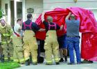 Firemen hoist a tarp at the scene of the fire.