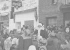 Santa Claus drew a big crowd when he made a visit to Minneota in this 1956 photo taken in front of the former Joy Theatre.  