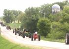  Several of the 25 tractors head down County Road 8 on Saturday. 