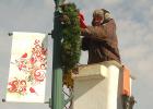 Minneota city worker Trent Hennen affixed holiday banners and lighted wreaths on business district light poles last week. The town continues to be getting a holiday boost with many homes also decorating for Christmas and several events are upcoming. 